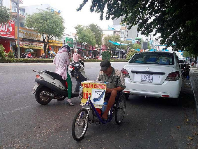 Ông Phan Văn Tuấn, 60 tuổi, người bán vé số tại bến Ninh Kiều, trốn nắng dưới bóng mát hàng cây. Ảnh: CẨM GIANG