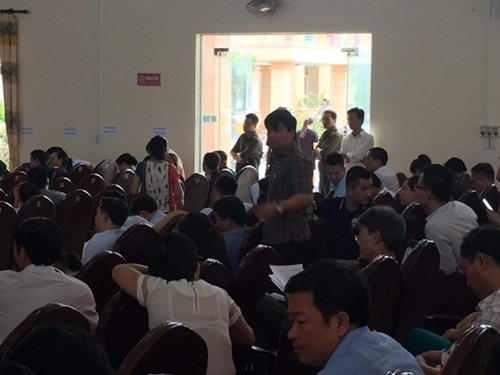 Ông Bùi Tuấn Anh - Bí thư Đảng uỷ xã Quảng Lợi (người đứng giữa đám đông) tham gia buổi đấu giá đất sáng 13.6. Ảnh: Hoàng Huy