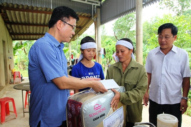 Bộ trưởng đến thăm và tặng quà cho gia đình chịu thiệt hại nặng nề do mưa lũ.