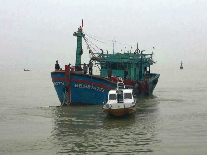 Vùng 3 Hải quân lai dắt tàu cá gặp nạn cùng 16 ngư dân về bờ. Ảnh: Anh Sơn.
