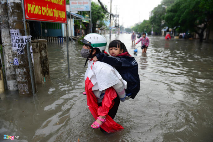 Một trong những phụ huynh khác vất vả lội nước đưa con đi học trên đường An Dương Vương, quận 6.