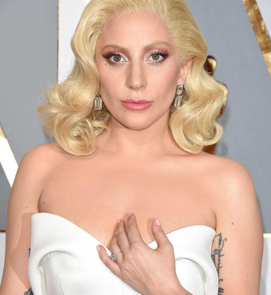 LADY GAGA - TRANG SỨC LORRAINE SCHWARTZ  Lady Gaga khẳng định cá tính độc đáo của mình khi chỉ chọn một đôi bông tai kiểu dáng đơn giản để khoe khéo sự đồng bộ với chiếc nhẫn đính hôn kim cương hình trái tim. Đôi bông tai dángnày do nhà kim hoàn Lorraine Schwartz chế tác với điểm nhấn chủ đạo là 2 viên kim cương giác cắt ngọc lục bảo trọng lượng 90 carat. Được biết mức giá của đôi bông tai này không "đơn giản tẹo nào" - 8 triệu USD (ngót ngét 180 tỷ VNĐ)