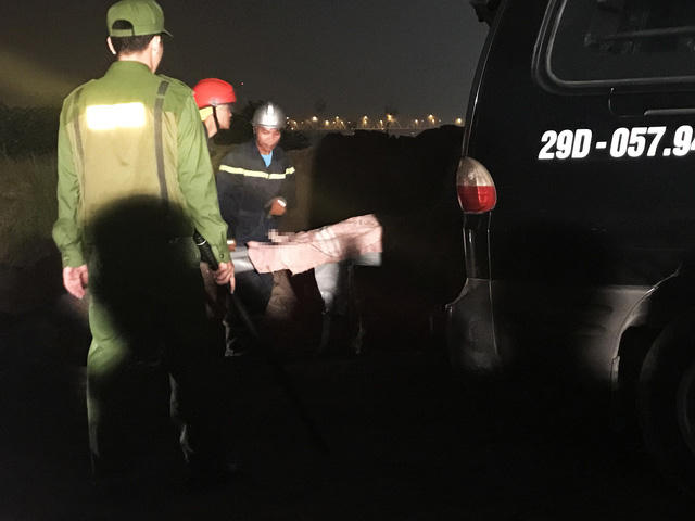 Thi thể nạn nhân được đưa lên xe cứu thương.