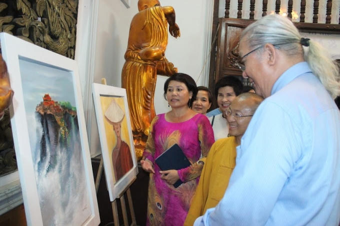 Họa sĩ Đàm Thủy giới thiệu các bức tranh cho hòa thượng Thích Nhật Từ, ông Nguyễn Trọng Cơ cùng du khách.