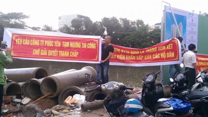 Người dân căng biểu ngữ để phản đối.