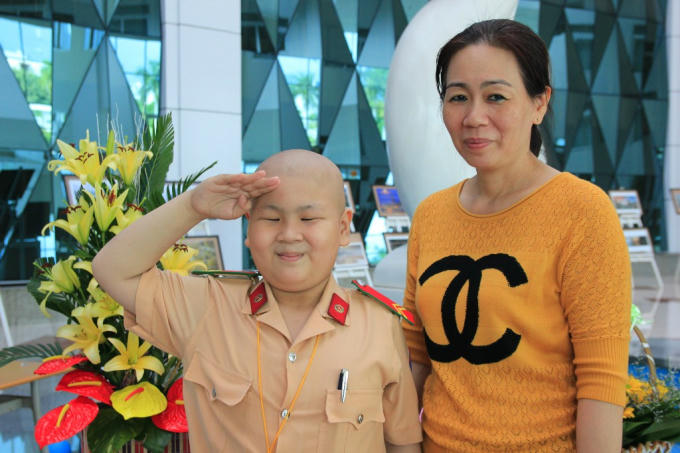 Hình ảnh cậu bé ung thư mơ làm CSGT Đỗ Tuấn Dũng và người mẹ Nguyễn Thị Thùy Dương.