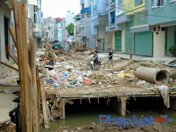 Trên mặt đường ngổn ngang rác thải sinh hoạt, vật liệu xây dựng, dưới mương dòng nước đen ngòm bốc mùi hôi thối.