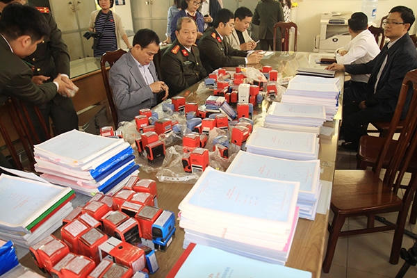 Tang vật thu giữ là 49 con dấu của các công ty khác nhau và 215 quyển hóa đơn giá trị gia tăng. Ảnh: theo CAND