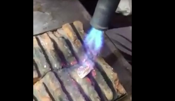 Món quà lưu niệm được mang đi thử chất liệu cấu thành lên nó. (Ảnh cắt từ clip).