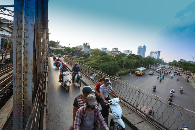 2018: Với tốc độ đô thị hoá nhanh, xung quanh cầu Long Biên nay là những con đường trải nhựa rộng, đẹp cùng những toà nhà hiện đại, thay thế cho những con đường mòn, những bãi cỏ mọc cao như cách đây 64 năm.
