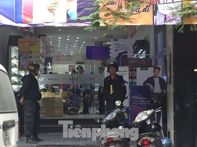 Lực lượng Cảnh sát có mặt khám xét tại cửa hàng Nhật Cường Mobile. (Ảnh: Tiền Phong)