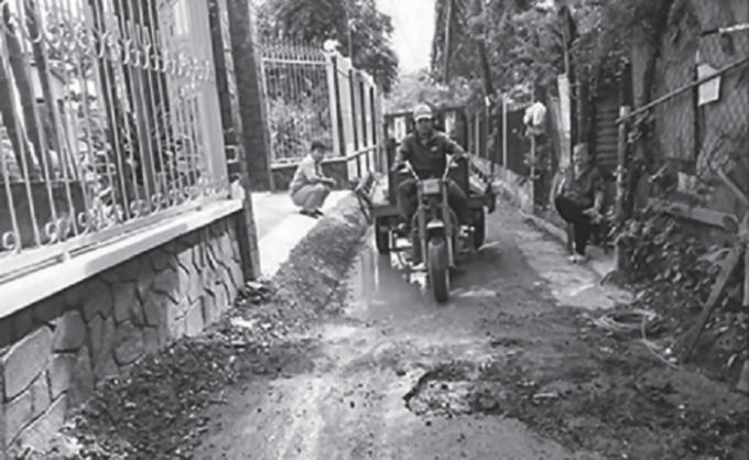 Lực lượng cưỡng chế đang dùng máy xới tung đoạn hẻm vừa trải nhựa.