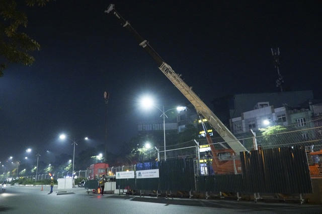 Cần cầu sẽ nâng cao những tấm hàng rào thép B40 lên trước sau đó tháo dỡ các khối bê-tông phía bên dưới và đưa lên thùng xe tải.