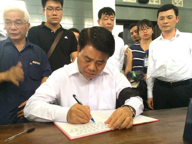 Ông Nguyễn Đức Chung - Chủ tịch UBND thành phố Hà Nội ghi sổ tang tại lễ viếng PGS Văn Như Cương.