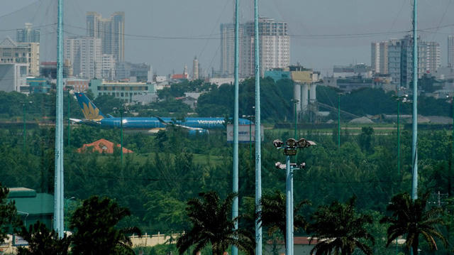 Một máy bay cỡ lớn vừa đáp hết đường băng khuất sau hàng rào lưới chắn bóng của khu tập golf.