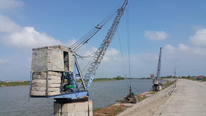 Hai cần cẩu trái phép sát chân đê tồn tại đã 5 năm nay vẫn chưa hề bị tháo dỡ.