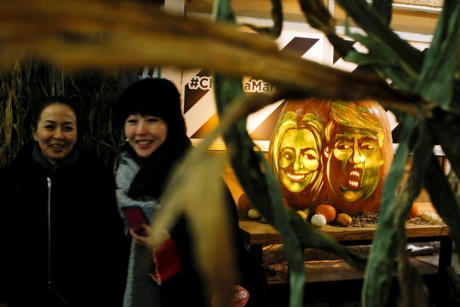 Quả b&iacute; ng&ocirc; h&igrave;nh khu&ocirc;n mặt của b&agrave; Clinton v&agrave; &ocirc;ng Trump tại chợ Chelsea ở New York ng&agrave;y 28-10 Ảnh: REUTERS