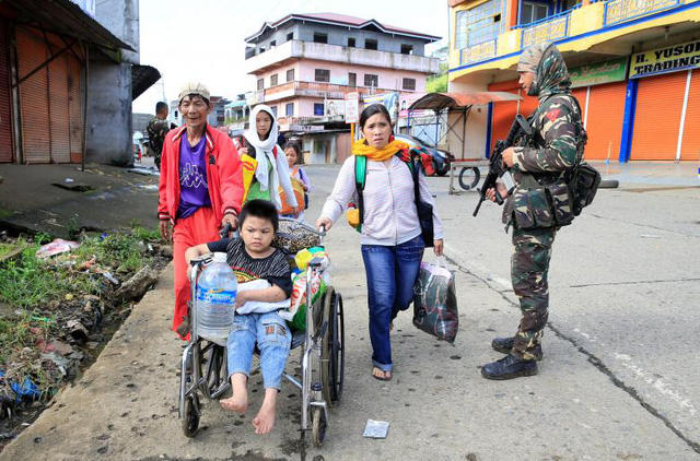Cảnh người dân tại Marawi sơ tán dưới sự bảo vệ của quân đội chính phủ.