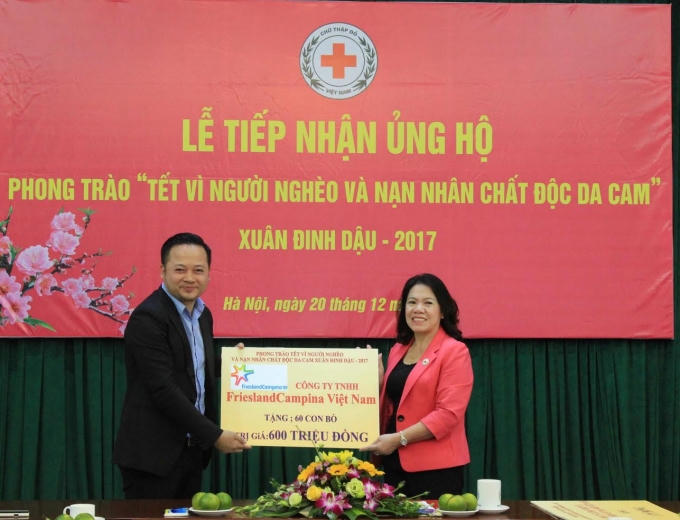 Đại diện FrieslandCampina Việt Nam (bên trái) trao bảng tượng trưng cho Chủ tịch Trung ương Hội Chữ thập đỏ Việt Nam.