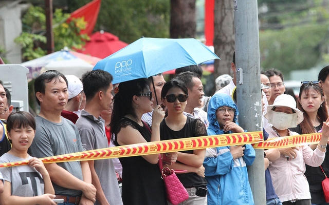 Người dân đứng dọc hai bên đường chờ đón Tổng thống Mỹ. (Ảnh: Dân trí)