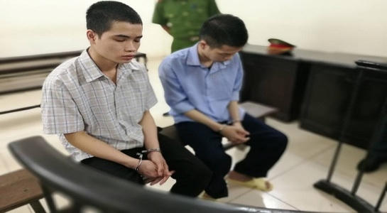 Hai bị cáo trước vành móng ngựa trong phiên tòa.