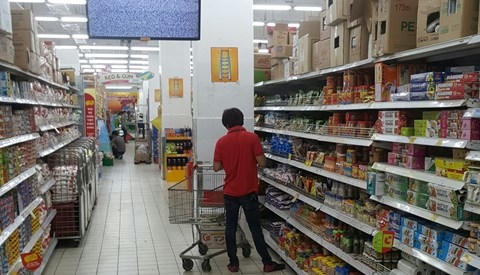 Nhân viên siêu thị Big C đi kiểm tra rút các sản phẩm hết hạn sử dụng ra khỏi kệ hàng.