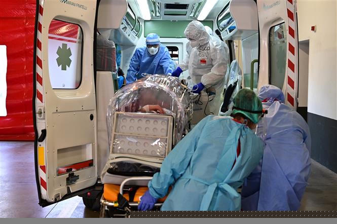 Nhân viên y tế chuyển bệnh nhân COVID-19 tới bệnh viện tại Varese, Italy, ngày 19/10/2020. Ảnh: AFP/ TTXVN