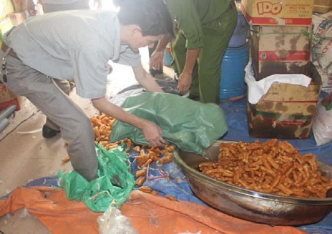 Ông Đới Văn Thịnh (trú phường Đội Cung, TP Vinh) sử dụng phụ gia, ngâm tẩm hóa chất không rõ nguồn gốc sản xuất quẩy. Ảnh: Phạm Băng.