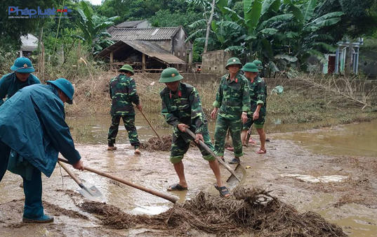 Bộ đội, dân quân giúp dân dọn dẹp môi trường, khắc phục hậu quả mưa lũ tại rốn lũ Thạch Định, Thạch Thành. (Ảnh: A.Thắng)