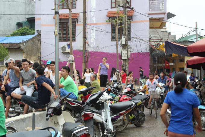 Mặc dù trời mưa nhưng những người dân trong làng, xã vẫn đầu trần đội mưa đến nghe ngóng tình hình.