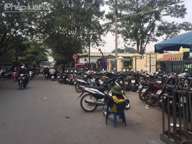 Bảo vệ bãi xe ngang nhiên ngồi giữa đường trông và chèo kéo khách.