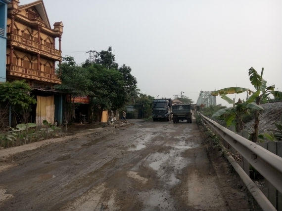 Người dân sinh sống tại dốc Thị Cầu, phải thường xuyên tưới nước ra đường, hoặc dùng bạt che để đối phó với bụi bẩn.