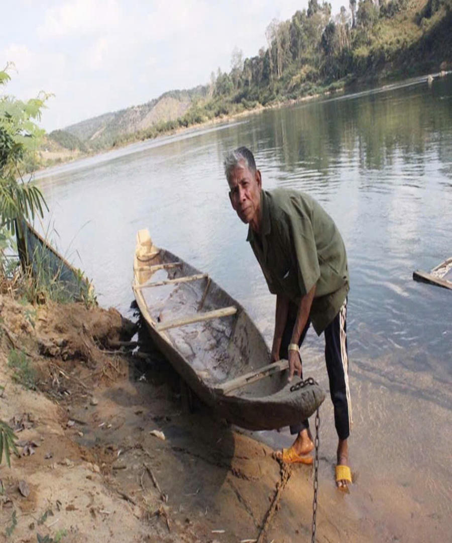 Ông Rơ Mah Hyen bên chiếc thuyền độc mộc cách đây 15 năm trước. Ảnh: P.T