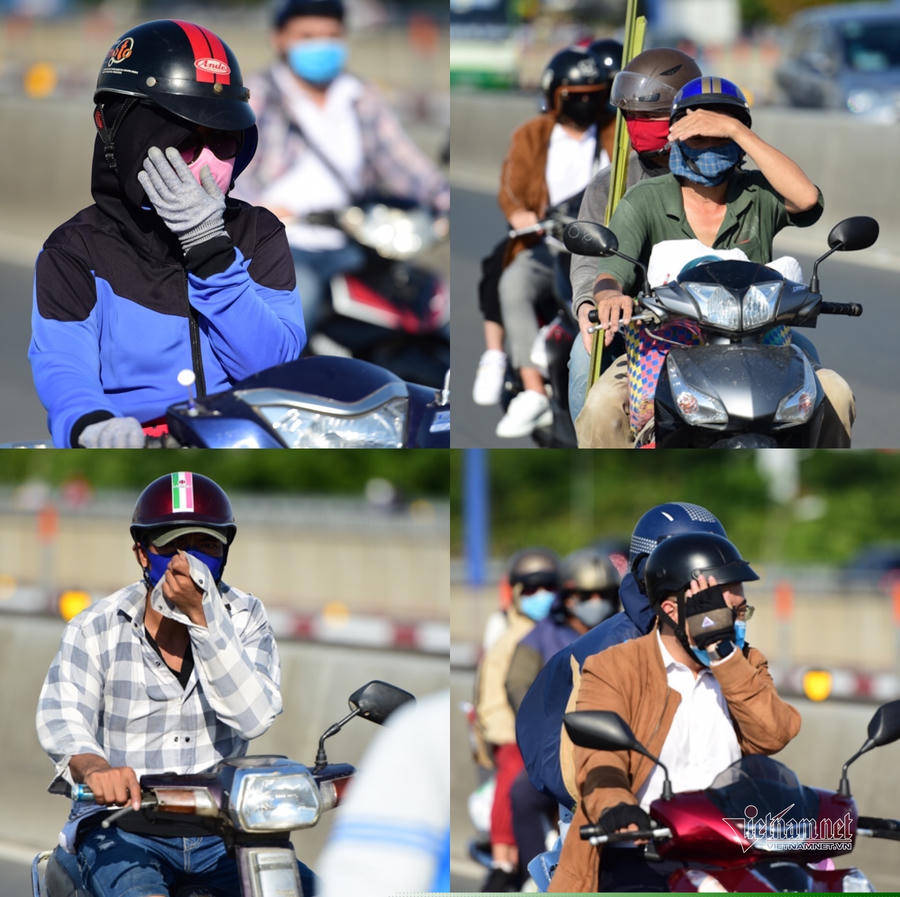 Người dân vừa lái xe, vừa dùng tay che nắng khi di chuyển trên đường vào trưa 9/5