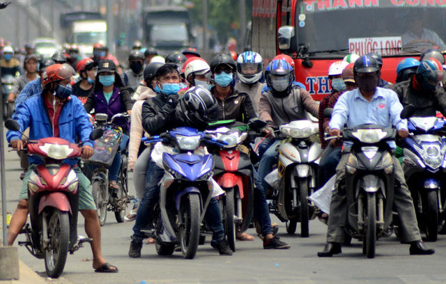 Tháo nón bảo hiểm tranh thủ “lấy gió trời” trong lúc chờ đèn đỏ.