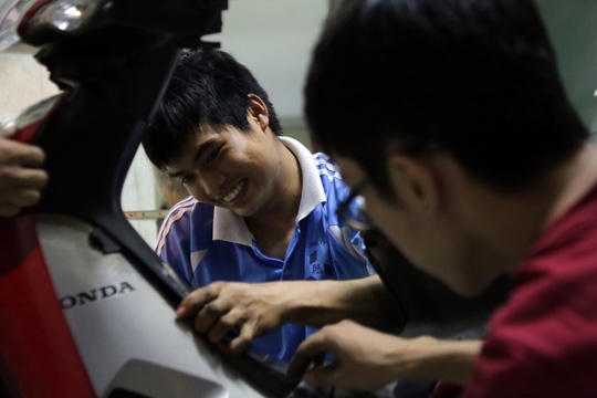 Hai chàng sinh viên Đại học Bách Khoa mượn đồ nghề để sữa chữa xe miễn phí cho các bạn sinh viên.