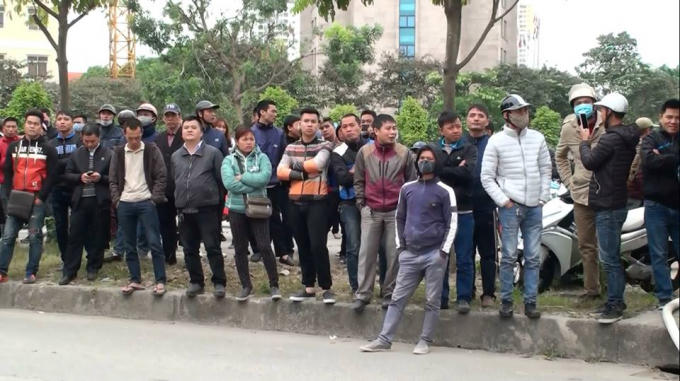 Người dân xung quanh hiếu kỳ đứng xem.