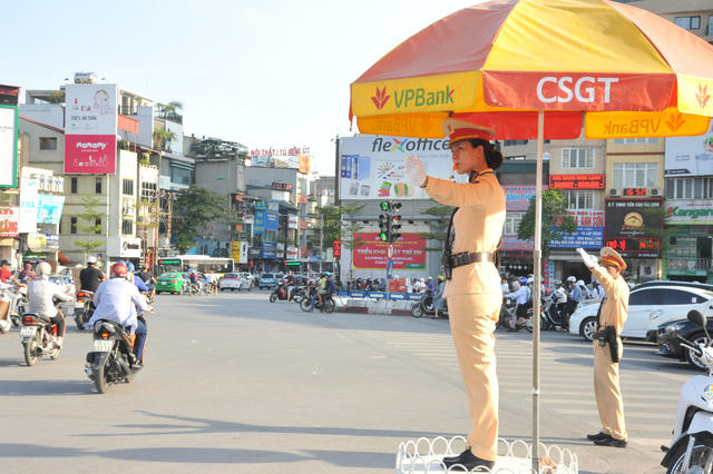 Nữ CSGT Hà Nội còn được nhiều người gọi là "bông hồng thép", cùng các đồng nghiệp nam đội nắng làm nhiệm vụ trong ngày nắng cao điểm.