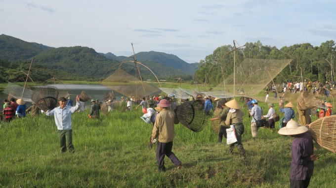 Sau hiệu lệnh mọi người ào xuống lòng đập để đánh cá.