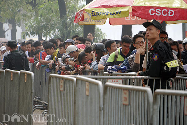 Quá mệt mỏi vì phải đứng xếp hàng lâu dưới trời nắng nóng, nhiều người gục đầu tựa vào 4 lớp rào do lực lượng cảnh sát cơ động dựng lên.