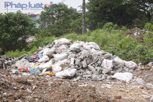 Những tải đựng phế liệu xây dựng được vứt thành đống bên đường.