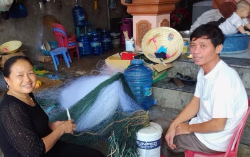 Hai vợ chồng ông Xuân chuẩn bị lưới cho thuyền ra khơi mới.