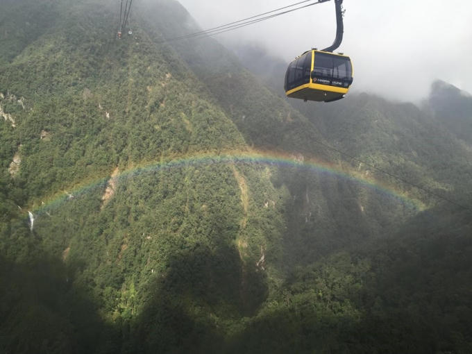 Từ cabin cáp treo, du khách thấy mình như đang bay trên thung lũng Mường Hoa khoáng đạt, phóng tầm mắt ra xa, dòng thác bạc như dải lụa ẩn hiện bên sườn núi cùng những vệt nắng chiếu xuống khu vực những bản làng người Mông gần đó. Anh Quang Thắng đến từ Hà Nội không khỏi phấn khích khi may mắn được tận hưởng cảm giác bay trên cầu vồng - một cảnh tượng bạn sẽ bắt gặp nhiều lần khi check in Fansipan mùa hạ. 