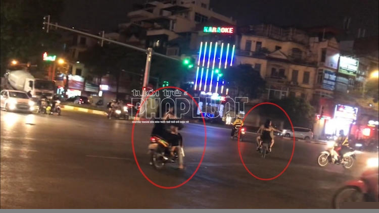 Các thanh niên đầu trần lái xe máy chở theo các cô gái "tay vịn'' chạy ngược chiều, vượt đèn đỏ, vi phạm Luật Giao thông đường bộ.