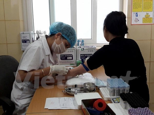 Nhân viên y tế lẫy máu xét nghiệm cho bệnh nhân tại Bệnh viện K. Ảnh: PV/Vietnam+.