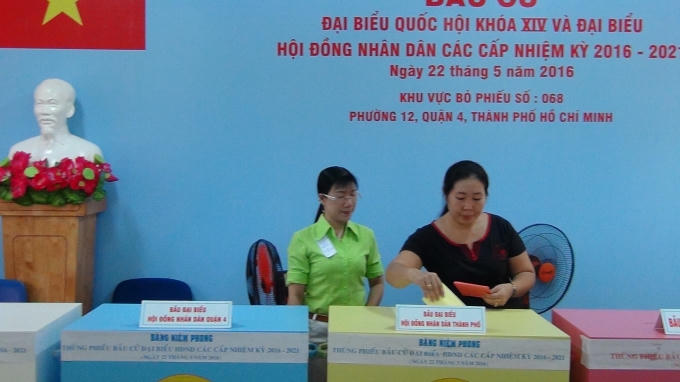 Cán bộ tổ bầu cử hướng dẫn cử tri bỏ phiếu.