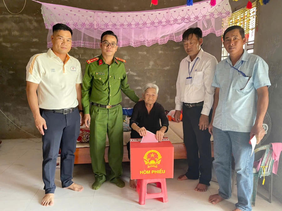 Công an xã Quách Phẩm và lực lượng an ninh, trật tự cơ sở đến tận nhà hỗ trợ cụ bà Nguyễn Thị Niềm (ngụ ấp Lung Vinh) thực hiện quyền bầu cử.