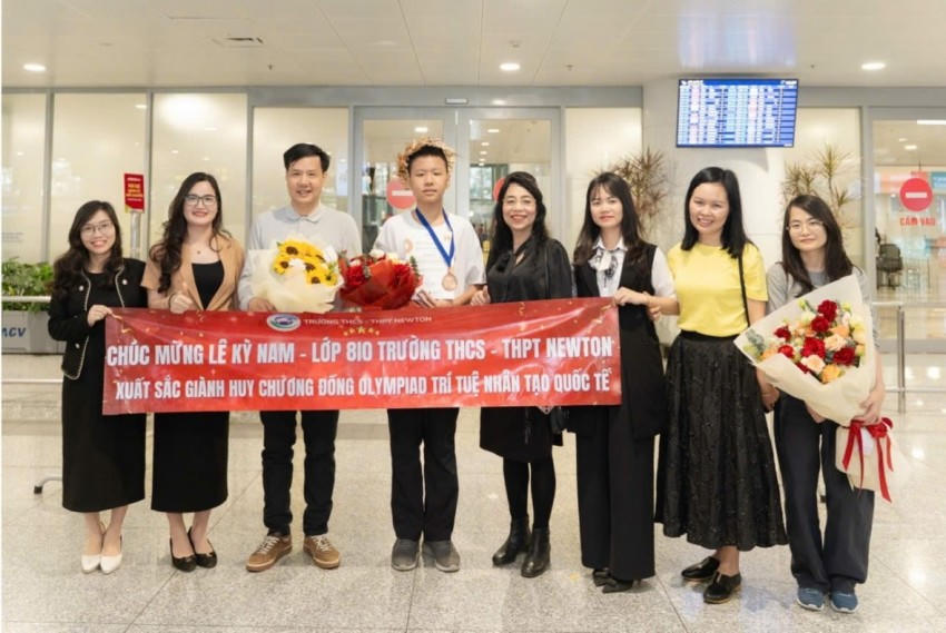 Ban lãnh đạo nhà trường và thầy cô chào đón Nam sinh Lê Kỳ Nam trở về từ kỳ thi Olympic AI quốc tế năm 2026.
