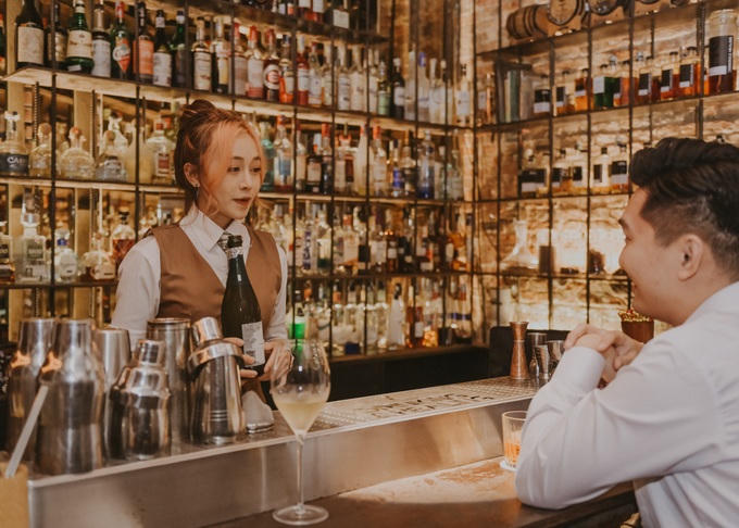 Đứng quầy bar, Phương vừa pha chế, vừa trò chuyện với khách hàng, thỉnh thoảng cô biểu diễn những kỹ năng với bình lắc, ly, hay chai rượu khiến họ thích thú.
