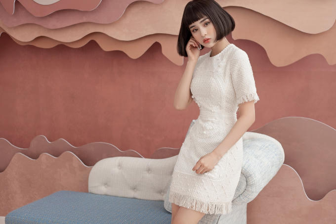 Ca sỉ HIền Hồ chọn chiếc đầm cocktail màu trắng tinh khôi bằng chết liệu vải tweed. Đây là loại vải có bề mặt sần, chống ẩm ướt và giữ ấm tốt, do đó thích hợp với những ngày chuyển mùa cuối năm.